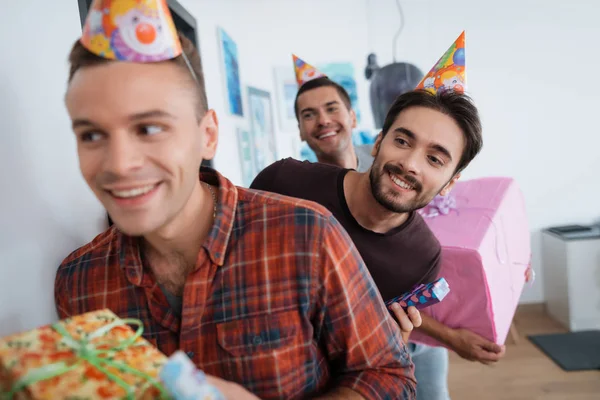 Les hommes avec des chapeaux d'anniversaire préparent une fête d'anniversaire surprise. Ils se préparent à rencontrer la fille d'anniversaire . — Photo