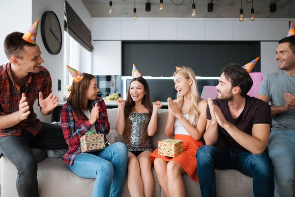 Fiesta en honor al cumpleaños. Los invitados dan sus regalos a la cumpleañera. La chica está muy feliz de recibir regalos . — Foto de Stock