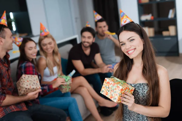 Festa em honra do aniversário. Os hóspedes dão os seus presentes à aniversariante. A menina está muito feliz por receber presentes . — Fotografia de Stock