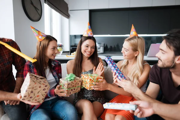 Festa em honra do aniversário. Os hóspedes dão os seus presentes à aniversariante. A menina está muito feliz por receber presentes . — Fotografia de Stock