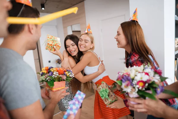 Pojkar och flickor uppfyller födelsedag flicka med gåvor. Flickan är mycket nöjd med oväntad överraskning. — Stockfoto