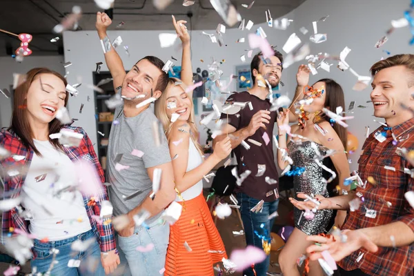 Guys and girls are dancing at a birthday party. They smile and have fun.