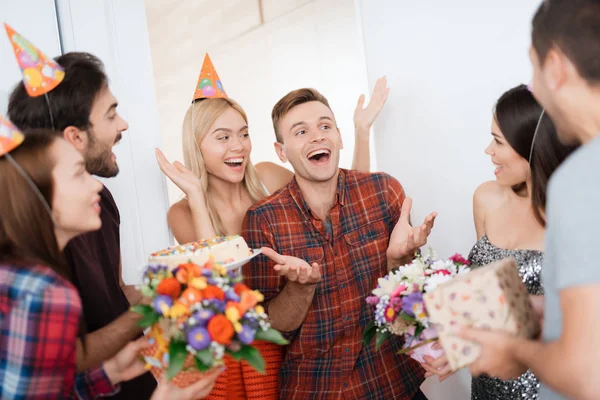 La chica le ha preparado una sorpresa para su cumpleaños. Los huéspedes están de pie alrededor de ellos . —  Fotos de Stock