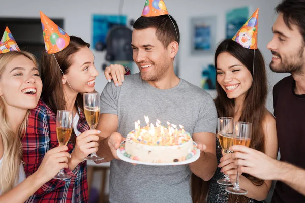 Bir adamın doğum günü ve arkadaşları onu tebrik. Konuklar doğum günü çocuğu duruyor. Adam bir pasta tutuyor.