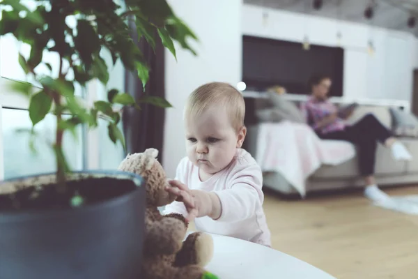 El bebé está desatendido. Mientras la mujer está hablando por teléfono, su hijo se arrastra en el suelo y se juega . — Foto de Stock