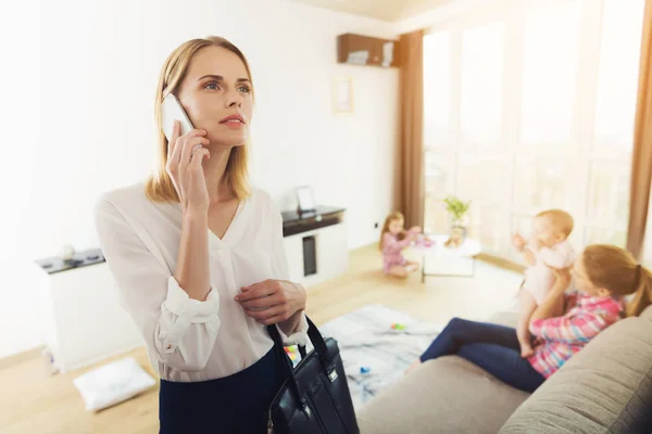 A mulher chegou em casa e falou ao telefone enquanto seus filhos estavam esfregando com a babá . — Fotografia de Stock