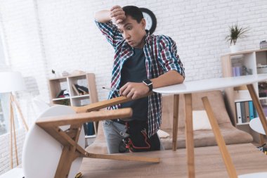 Genç adam onun sehpa ve tabureler kat kendisine çalışır.