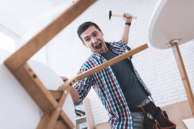 Genç adam onun sehpa ve tabureler kat kendisine çalışır.