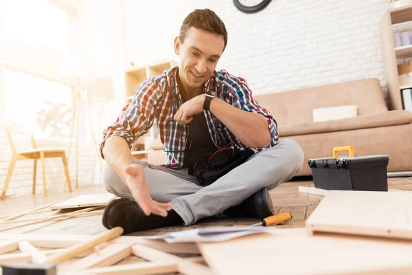 El joven intenta doblar su estantería . — Foto de Stock