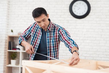 Genç adam onun kitaplık kat kendisine çalışır.