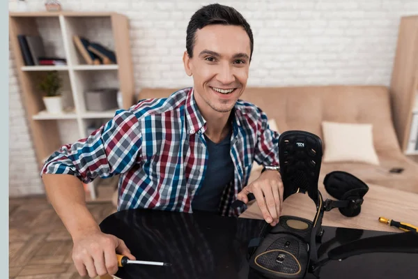 El joven intenta reparar el snowboard él mismo. . — Foto de Stock