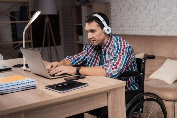 A young disabled man works at home.