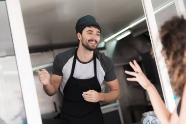 Siyah elbiseli güzel bir kız gıda kamyon yaklaştı. O bir sipariş satıcıdan yapar