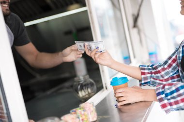 Güzel bir kız bir ekose gömlekli bir restorandaki kahve satın alır. O satıcı öder