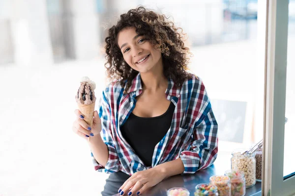 Una hermosa chica en una camisa a cuadros pidió helado de chocolate. Un hombre en un restaurante móvil le da helado. —  Fotos de Stock