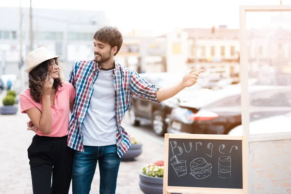 A young couple walks down the street to a mobile diner. They want to place an order — Stock Photo, Image