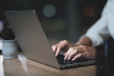 Kız bir dizüstü bilgisayar ile karanlık ofiste geç saate kadar çalışıyor. Genç güzel işkadını kız ofiste.