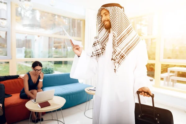 Мужчина в арабской одежде держит чемодан . — стоковое фото