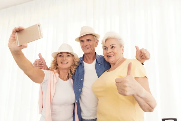 An elderly woman and elderly man making selfie. Elderly woman taking photo and smiling.