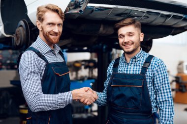 Baba ve oğul otomatik hizmetinde çalışır. İki mekanik araba ayrıntıları ile çalışmak.