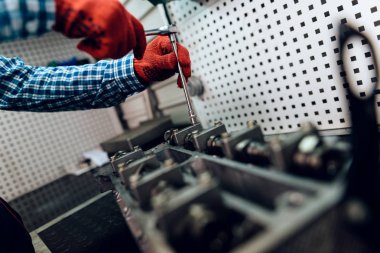 Tamirci çalışırken yakın çekim fotoğraf. Araçlar ve arabadan ayrıntıları ile çalışır.