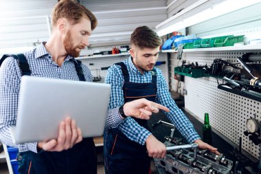 Baba ve oğul otomatik hizmetinde çalışır. İki mekanik araba ayrıntıları ile çalışmak.