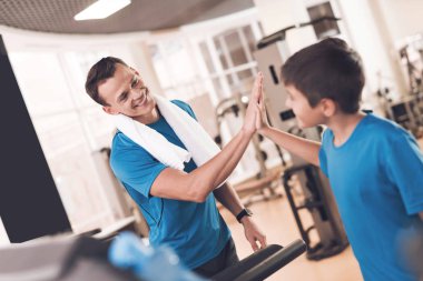 Baba ve oğul aynı giysileri içinde jimnastik salonu. Baba ve oğul sağlıklı bir yaşam tarzı yol.