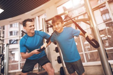 Baba ve oğul aynı giysileri içinde jimnastik salonu. Baba ve oğul sağlıklı bir yaşam tarzı yol.