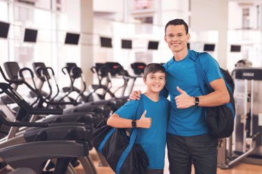 Baba ve oğul aynı giysileri içinde jimnastik salonu. Baba ve oğul sağlıklı bir yaşam tarzı yol.
