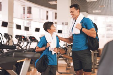 Baba ve oğul aynı giysileri içinde jimnastik salonu. Baba ve oğul sağlıklı bir yaşam tarzı yol.