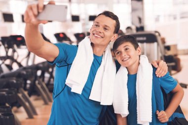 Baba ve oğul aynı giysileri içinde jimnastik salonu. Baba ve oğul sağlıklı bir yaşam tarzı yol.