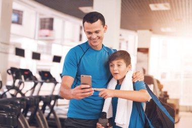 Baba ve oğul aynı giysileri içinde jimnastik salonu. Baba ve oğul sağlıklı bir yaşam tarzı yol.