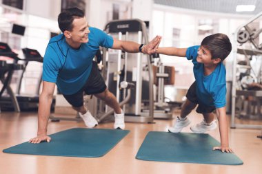 Baba ve oğul aynı giysileri içinde jimnastik salonu. Baba ve oğul sağlıklı bir yaşam tarzı yol.