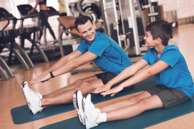 Baba ve oğul aynı giysileri içinde jimnastik salonu. Baba ve oğul sağlıklı bir yaşam tarzı yol.