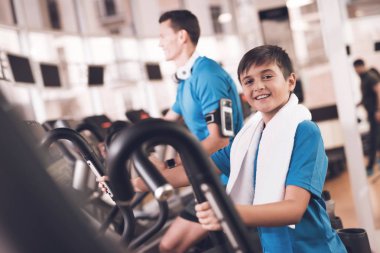 Baba ve oğul aynı giysileri içinde jimnastik salonu. Baba ve oğul sağlıklı bir yaşam tarzı yol.