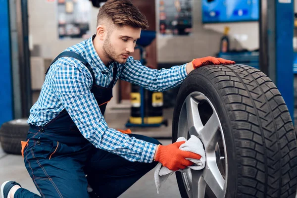 A young man works at a service station. The mechanic is engaged in repairing the car. — Stock Photo, Image