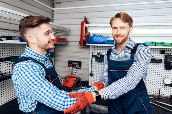 Father and son work at the auto service. Two mechanics work with the details of the car. — Stock Photo, Image