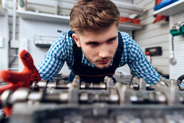 Een jonge man werkt bij een tankstation. De monteur houdt zich bezig met het repareren van de auto. — Stockfoto