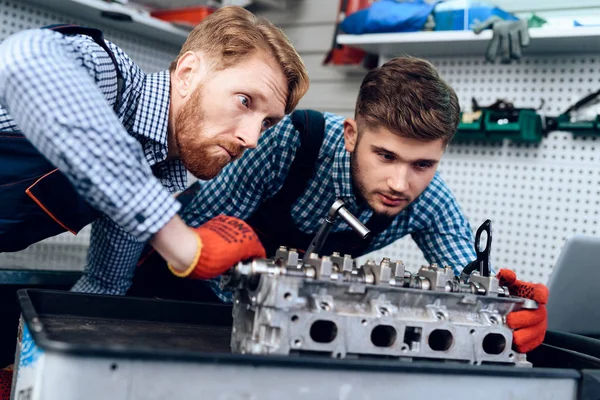 Pai e filho trabalham no serviço de automóveis. Dois mecânicos trabalham com os detalhes do carro . — Fotografia de Stock