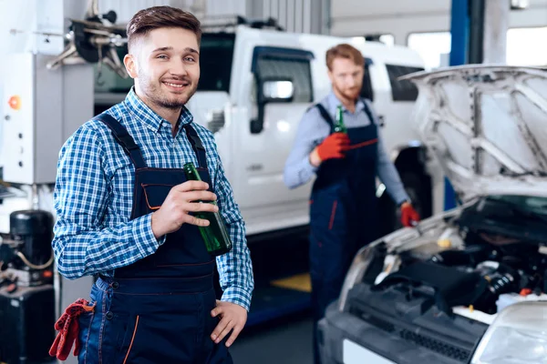 Pai e filho trabalham no serviço de automóveis. Dois mecânicos trabalham com os detalhes do carro . — Fotografia de Stock