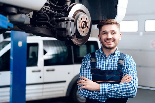 Ein junger Mann arbeitet an einer Tankstelle. der Mechaniker ist mit der Reparatur des Autos beschäftigt. — Stockfoto