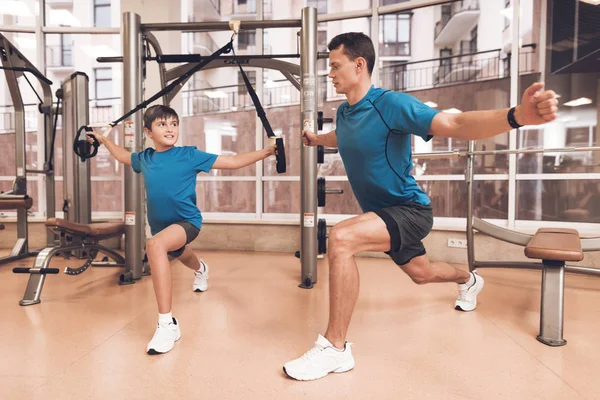 Dad and son in the same clothes in gym. Father and son lead a healthy lifestyle.