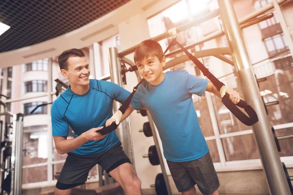Dad and son in the same clothes in gym. Father and son lead a healthy lifestyle.
