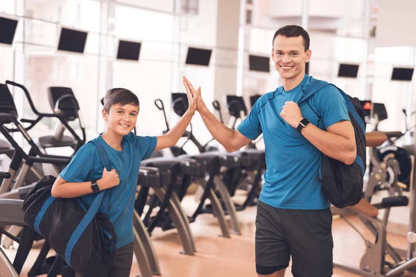 Papá e hijo con la misma ropa en el gimnasio. Padre e hijo llevan un estilo de vida saludable . — Foto de Stock