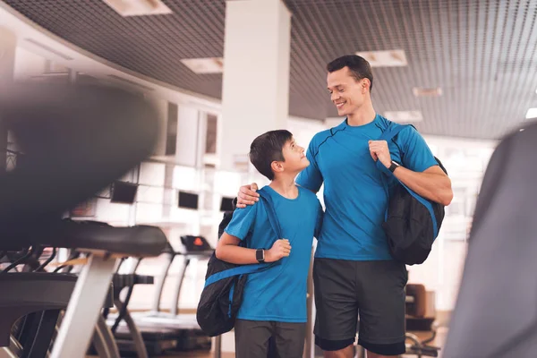 Papá e hijo con la misma ropa en el gimnasio. Padre e hijo llevan un estilo de vida saludable . — Foto de Stock