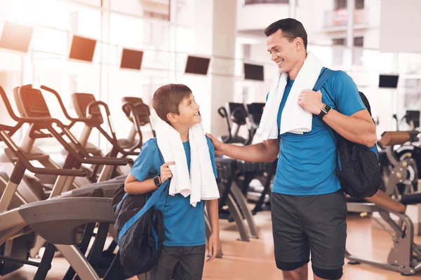 Papá e hijo con la misma ropa en el gimnasio. Padre e hijo llevan un estilo de vida saludable . — Foto de Stock