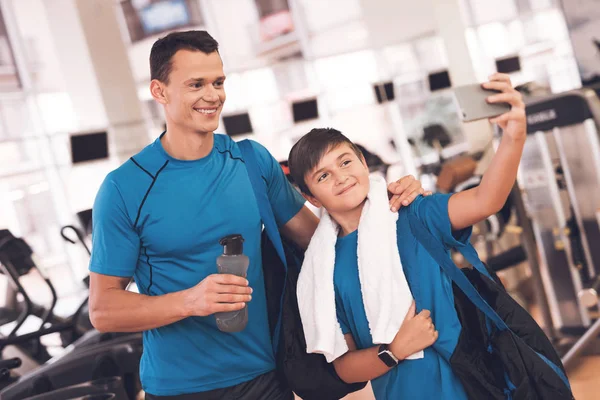 Papá e hijo con la misma ropa en el gimnasio. Padre e hijo llevan un estilo de vida saludable . — Foto de Stock