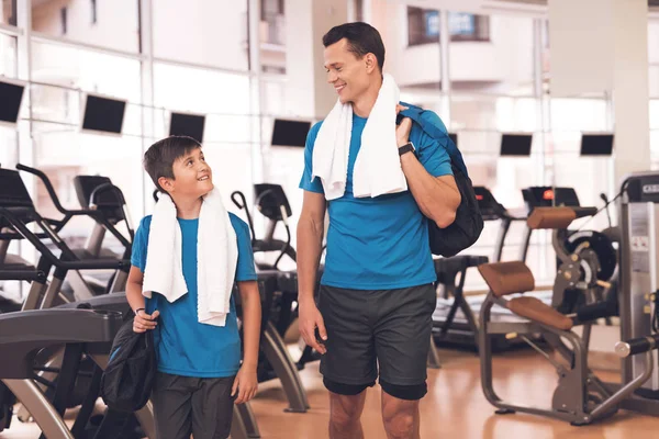 Papá e hijo con la misma ropa en el gimnasio. Padre e hijo llevan un estilo de vida saludable . — Foto de Stock