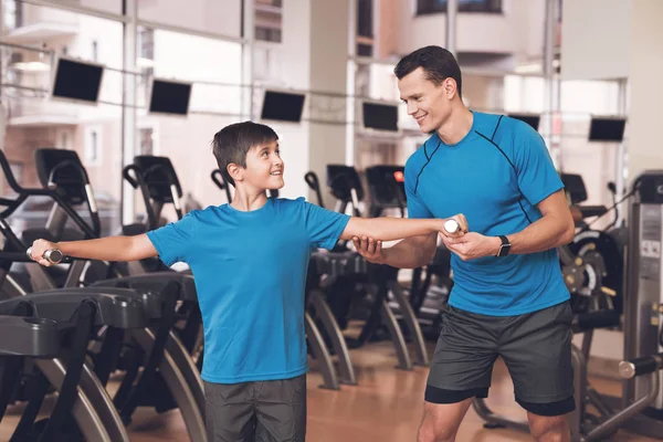 Papá e hijo con la misma ropa en el gimnasio. Padre e hijo llevan un estilo de vida saludable . — Foto de Stock