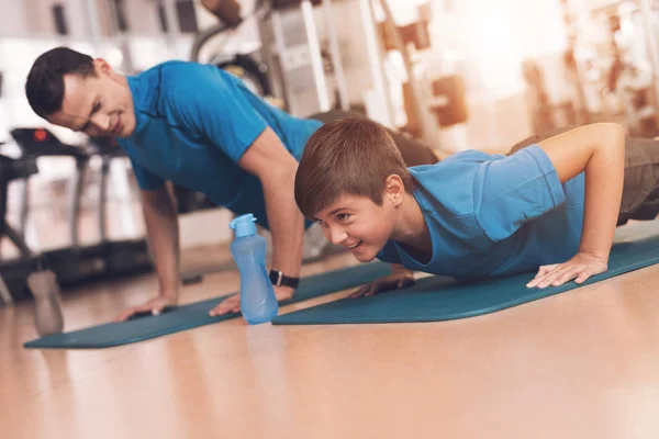 Papá e hijo con la misma ropa en el gimnasio. Padre e hijo llevan un estilo de vida saludable . — Foto de Stock